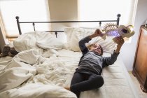Elementary age boy playing with fish toy on bed — Stock Photo