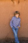 Portrait of elementary age boy against adobe wall — Stock Photo