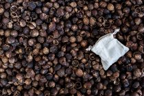 High angle close-up of dried brown soap nuts and reusable bag, full frame. — Stock Photo
