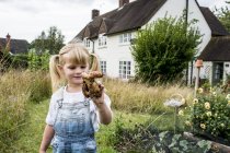 Блондинка, стоящая в саду, держа картошку . — стоковое фото