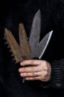 Close-up de pessoa segurando uma seleção de lâminas de faca parcialmente enferrujadas e serrilhadas . — Fotografia de Stock