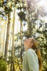 Jugendlicher Wanderer blickt auf Espen im Wald mit leuchtenden Herbstfarben — Stockfoto