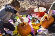 Elementary age boy carving pumpkins outdoors at Halloween. — Stock Photo