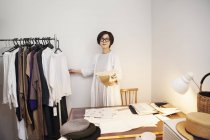 Mujer japonesa en gafas trabajando en un escritorio en una pequeña boutique de moda . - foto de stock