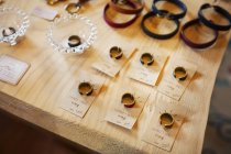 Alto ángulo de cerca de los anillos de los dedos y pulseras de cuero en una mesa en una tienda de cuero . - foto de stock