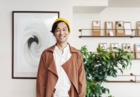 Maschio giapponese professionale in piedi in un co-working spazio, sorridente in macchina fotografica . — Foto stock