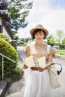 Femme japonaise portant un chapeau et tenant la carte debout à l'extérieur du temple bouddhiste . — Photo de stock