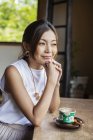 Smiling Japanese woman sitting at table in Japanese restaurant. — Stock Photo