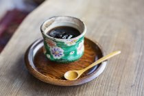 High angle close-up of Japanese condiment in green bowl on wooden plate. — Stock Photo