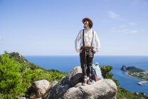 Japanese woman wearing hat standing on a rocks on cliff with ocean scenery. — Stock Photo