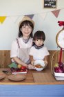 Giapponese donna e ragazzo in piedi in una fattoria negozio, preparare il cibo
. — Foto stock