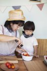 Японська жінка і хлопчик стоять у фермерському магазині, готуючи їжу.. — стокове фото