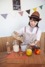 Japanese woman wearing hat standing in a farm shop with a selection of foods and condiments in glass jars. — Stock Photo