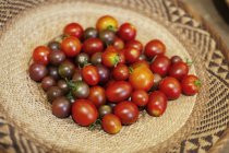 High angle close-up of a bowl of fresh tomatoes in a farm shop. — Stock Photo