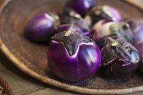High angle close-up of a selection of fresh purple aubergines in a farm shop. — Stock Photo