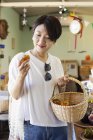 Donna giapponese che acquista peperoni freschi in un negozio di fattoria . — Foto stock
