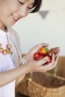 Alto angolo di primo piano della donna giapponese che tiene i pomodori freschi . — Foto stock
