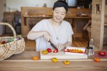 Japanese woman preparing fresh vegetables in a vegetarian cafe. — Stock Photo