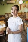 Femme japonaise souriante debout dans un magasin de ferme, regardant à la caméra
. — Photo de stock