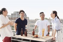 Gruppe junger japanischer Männer und Frauen feiert Party auf dem Dach in urbaner Umgebung. — Stockfoto