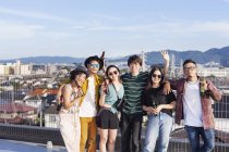 Group of young Japanese men and women standing on rooftop in urban setting. — Stock Photo