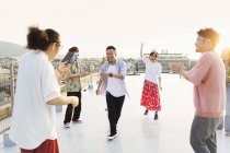 Група молодих японських чоловіків і жінок танцюють на даху в місті.. — стокове фото