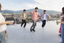 Giovani uomini giapponesi che ballano sul tetto in ambiente urbano . — Foto stock