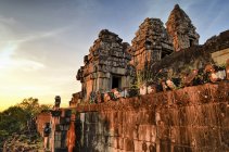 Angkor Wat, a 12th century historic Khmer temple and UNESCO world heritage site. Arches and carved stone blocks and steps at sunset. — Stock Photo