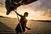 Woman holding wine glass standing on board a boat, sunset dinner cruise on Indian Ocean. — Stock Photo