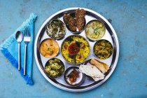 Großaufnahme eines traditionellen indischen Mittagessens mit Reis, verschiedenen Curries, Essiggurken und Gemüse. — Stockfoto