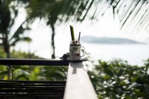 Close-up of Tom Yum cocktail with coconut-infused liquour on balustrade of balcony. — Stock Photo