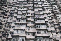 Vista de ángulo bajo de la fachada del imponente complejo residencial con ventanas y balcones, Hong Kong, China - foto de stock