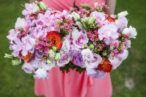 High angle close-up of woman holding two bouquets of flowers with pink roses. — Stock Photo