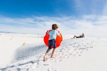 Garçon de 6 ans escaladant une dune de sable — Photo de stock