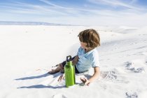 6-летний мальчик с бутылкой зеленой воды, памятник Белым пескам — стоковое фото