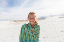 Niña adolescente en una toalla sobre la arena, Tierra Blanca Monumento Nat 'l, NM. - foto de stock