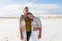 Uma mãe e sua filha adolescente lado a lado, braços ao redor da cintura, em um espaço aberto — Fotografia de Stock