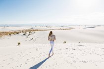 13 year old girl standing looking at a vast open space of sand dunes. — Stock Photo