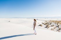 13-jähriges Mädchen steht und blickt auf eine riesige Weite aus Sanddünen. — Stockfoto