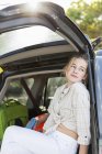 13 year old girl in back of SUV with luggage — Stock Photo