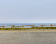 Parking lot with fencing and ice plant ground cover, by the ocean — Stock Photo