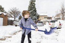 Six year old boy shoveling snow in driveway — Stock Photo