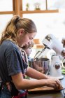 Thirteen year old teenage girl and her 6 year old brother in the kitchen using a mixing bowl — Stock Photo