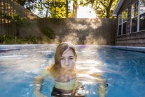 Niña de 13 años nadando en una piscina. - foto de stock