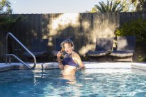 Jeune fille de 13 ans nageant dans une piscine — Photo de stock