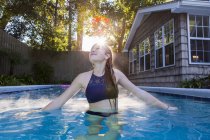 Menina de 13 anos nadando em uma piscina — Fotografia de Stock