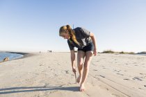 Adolescente ragazza giocare in dune di sabbia, in spiaggia — Foto stock
