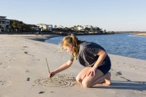 Une adolescente joue dans les dunes de sable, à la plage — Photo de stock
