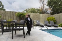 Garçon de 6 ans portant une tenue officielle debout près de la piscine — Photo de stock