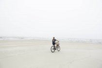 Дівчинка-підліток їздить на піщаному узбережжі біля океану, острів Сен-Сімонс, Джорджія. — стокове фото